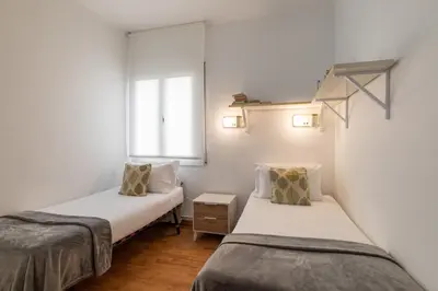 two beds in a small room with a window at Stay U-nique Apartments Salva II in Barcelona