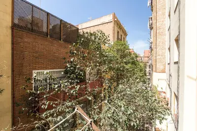 a brick building with trees on the side of it at Stay Unique Apartments Corsega in Barcelona