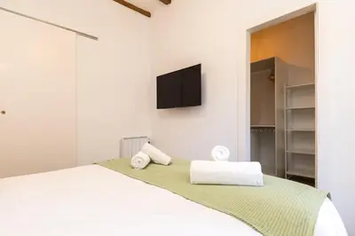 a bedroom with a bed with a tv on the wall at Stay Unique Apartments Corsega in Barcelona