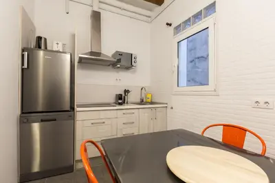 a kitchen with a table and a refrigerator at Stay Unique Apartments Corsega in Barcelona