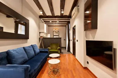 a living room with a blue couch and a tv at Stay U-nique Apartments Obradors in Barcelona