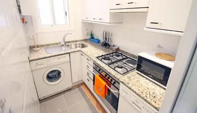 a white kitchen with a sink and a washing machine at Sagrada Familia Apartamento eco friendly in Barcelona