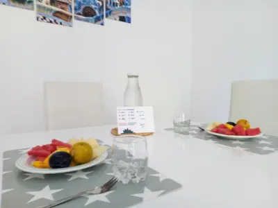 a table with a plate of fruit and a glass of water at Sagrada Familia Apartamento eco friendly in Barcelona