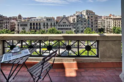a balcony with a table and chairs and a view of a city at Habitat Apartments Paseo de Gracia in Barcelona