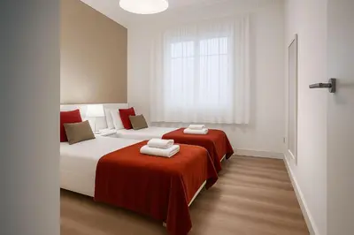 a bedroom with two beds and a window at Habitat Apartments Paseo de Gracia in Barcelona