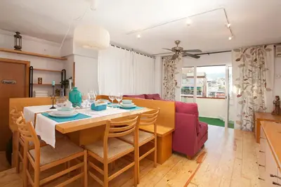 a dining room and living room with a table and chairs at Atic Gaudi-Gracia in Barcelona