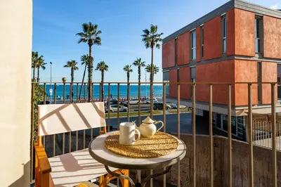 a table and chairs on a balcony with a view of the ocean at Kronos on the beach Suite 2 in Barcelona