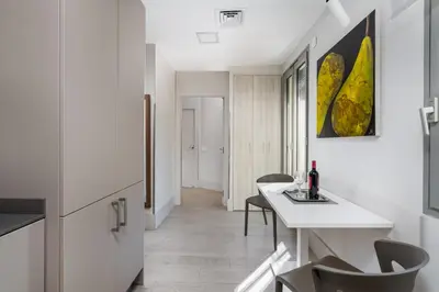 a white kitchen with a table and chairs at Kronos on the beach Suite 4 in Barcelona