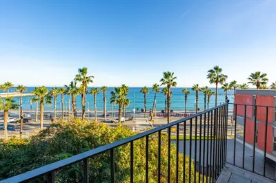 a balcony with palm trees and the ocean at Kronos on the beach Suite 4 in Barcelona