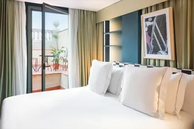 a bedroom with a large white bed with a balcony at One Shot Aragó in Barcelona