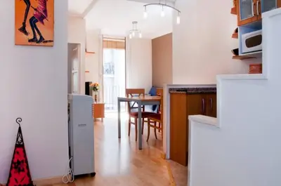 a kitchen and living room with a table and a dining room at Bbarcelonapartment Acogedor, tranquilo con Balcón in Barcelona