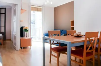 a dining room and living room with a blue table and chairs at Bbarcelonapartment Acogedor, tranquilo con Balcón in Barcelona