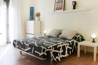a bedroom with a bed with a black and white comforter at Apartamento Cerca del Mar in Badalona