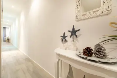 a white hallway with a table with christmas decorations at Pere Serafi 2 bedroom apartment in Barcelona