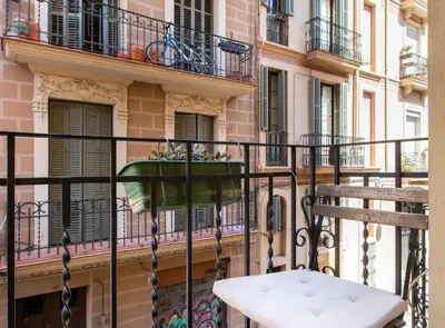a balcony with a chair and a flower pot on a building at Pere Serafi 2 bedroom apartment in Barcelona