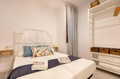 a bedroom with a white bed with towels on it at Pere Serafi 2 bedroom apartment in Barcelona