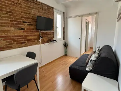 a living room with a couch and a brick wall at Ático ideal en Barcelona in Barcelona