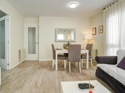 a living room with a table and a couch at Beach Matucana Apartment by Hello Homes Sitges in Sitges