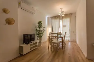 a living room with a table and chairs and a television at INNOUTHOME Apartamento Eixample Barcelona in Barcelona