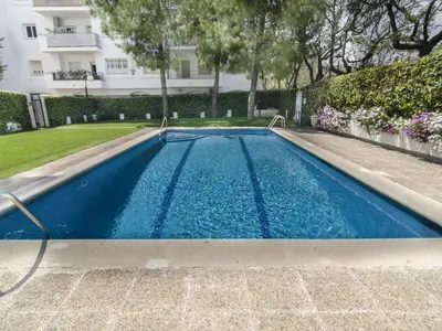 a swimming pool with blue water in front of a building at Sitges Spaces Oasis Suites- 4 Bedroom, 4 Ensuite Bathrooms, Terrace, Pool, Sitges Centre in Sitges