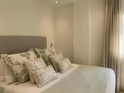 a bedroom with a bed with white pillows at Sitges Spaces Oasis Suites- 4 Bedroom, 4 Ensuite Bathrooms, Terrace, Pool, Sitges Centre in Sitges
