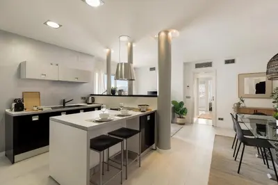 a kitchen with black and white counters and a table at Click&Flat Luxury Tetuan in Barcelona