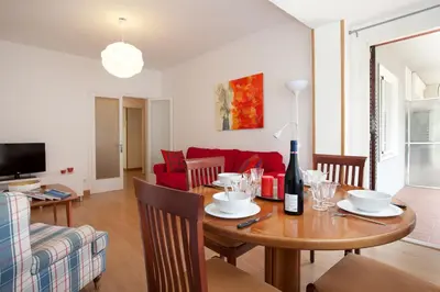 a living room with a table and a red couch at Click&Flat Floridablanca in Barcelona
