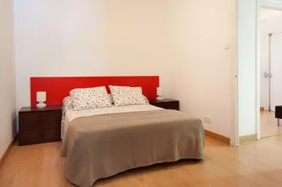 a bedroom with a large bed with a red headboard at Click&Flat Floridablanca in Barcelona