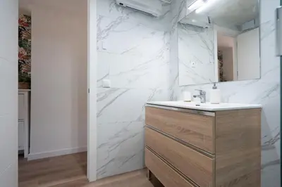 a white bathroom with a sink and a mirror at Beach, Restaurants and Views in Castelldefels