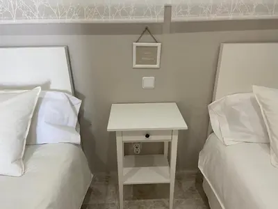 two beds with white pillows and a table between them at Karin Palma Fiesta-Vallpineda-Sitges in Sant Pere de Ribes