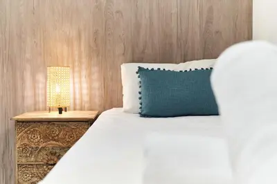 a bed with a blue pillow and a lamp at HA Diputació terrace apartment in Barcelona