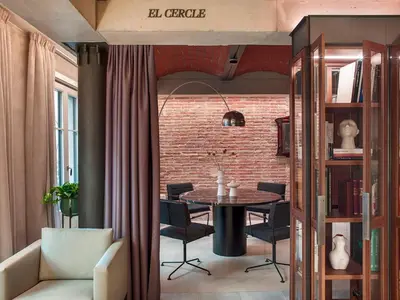 a dining room with a table and a brick wall at Antiga Casa Buenavista in Barcelona