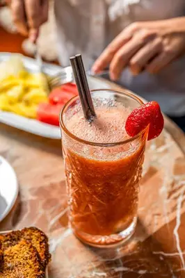 a drink with a strawberry in it on a table at Antiga Casa Buenavista in Barcelona