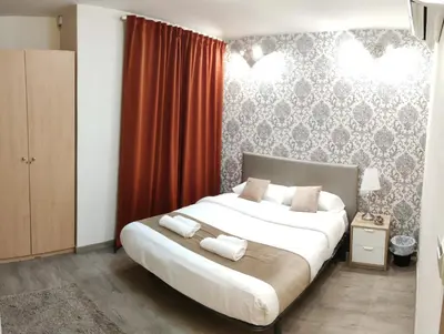 a bedroom with a large bed with red curtains at Guest House Barcelona Bruc in Barcelona