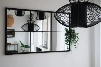 a mirror hanging on a wall with a plant at Sunny and modern apartment ideal for groups in Barcelona