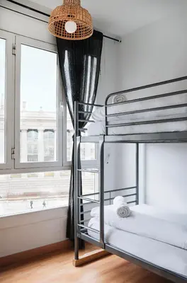 two bunk beds in a room with a window at Sunny and modern apartment ideal for groups in Barcelona