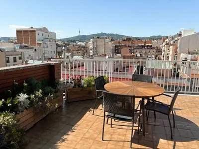 a table and chairs on a balcony with a view at Casa Cosi - Industria in Barcelona