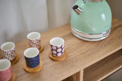 a group of cups on a wooden table next to a juicer at Casa Cosi - Industria in Barcelona