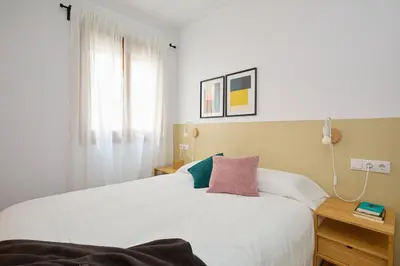 a bedroom with a white bed and a window at Casa Cosi - El Farro 3 in Barcelona
