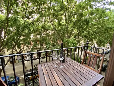 a wooden table with two wine glasses on a balcony at Sant antoni apartment in Barcelona