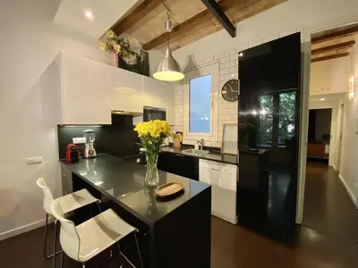 a kitchen with a black counter and white cabinets at Sant antoni apartment in Barcelona