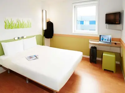 a bedroom with a large white bed and a window at Ibis Budget Barcelona Sant Andreu De La Barca in Sant Andreu de la Barca