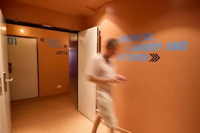 a man walking through a hallway with a sign on the wall at Latroupe Poblenou Beach in Barcelona
