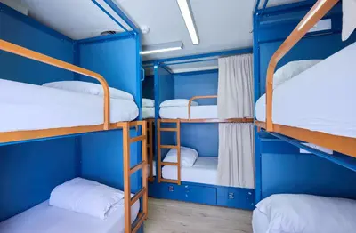 a group of bunk beds in a room with blue walls at Latroupe Poblenou Beach in Barcelona