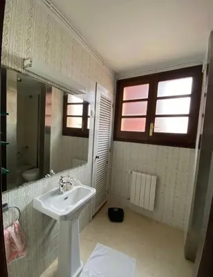 a white bathroom with a sink and a mirror at Medieval tower & villa by the sea in Caldes d'Estrac