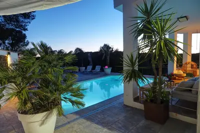 a swimming pool with palm trees in a house at Villa Elysian by Hello Homes Sitges in Sant Pere de Ribes
