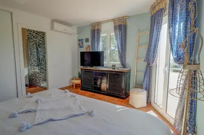 a bedroom with a bed and a tv and windows at Villa Elysian by Hello Homes Sitges in Sant Pere de Ribes