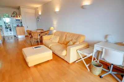 a living room with a couch and a table at Tropical Terrace Apartment by Hello Homes Sitges in Sitges