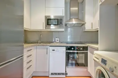 a white kitchen with a stove and a microwave at Alcam Anglesola in Barcelona
