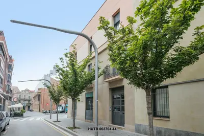 a street with trees in front of a building at Alcam Anglesola in Barcelona